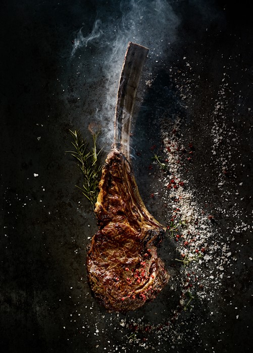 Food fotografie tomahawk steak met zout en kruiden
