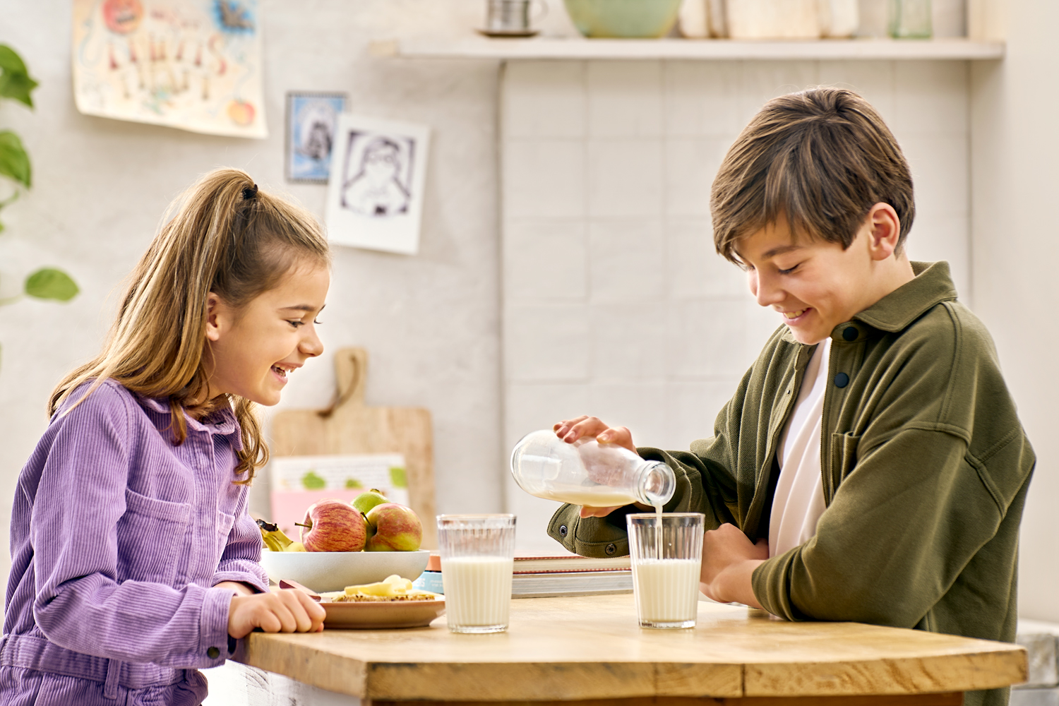 Lifestyle fotografie jongen en meisje schenken melk in