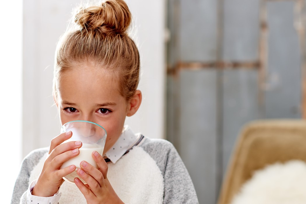 Lifestyle fotografie meisje drink uit een glas melk