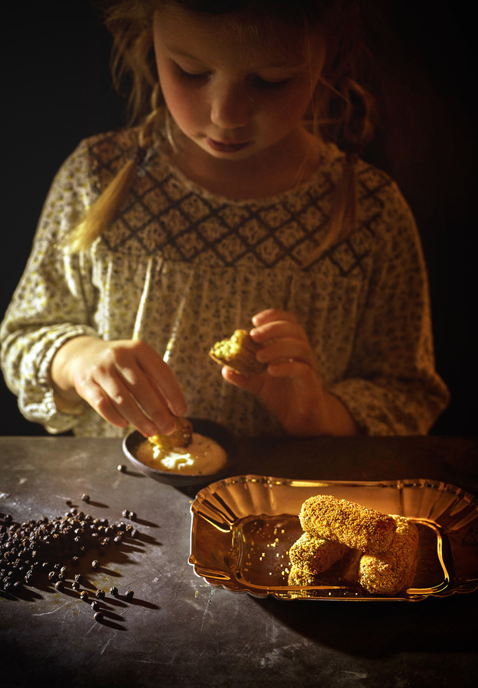 Lifestyle fotografie meisje met kroketten in donkere sfeer